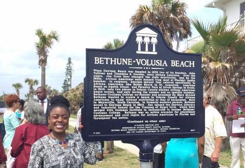 Dr. Preston next to a plaque of Bethune-Volusia Beach